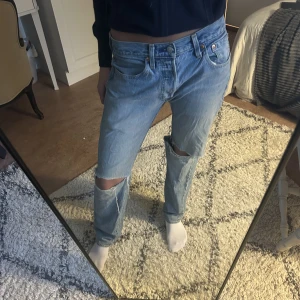 Levis jeans  - Säljer mina snygga blå Levis jeans i modellen 501 med hål då de inte kommer till användning. Storleken är waist 29 och length 32. De är sparsamt använda och därav i väldigt bra skick! 