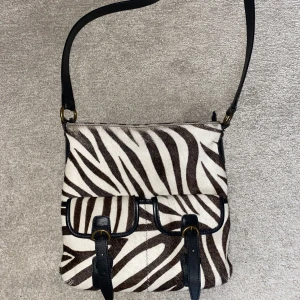 Zebraväska Hobbs - Sidoväska i skinn och päls från brittiska märket Hobbs. Troligtvis päls från ko som är målad som zebra. I gott använt skick, många bra fack. Jag på bild är 160cm lång🌸