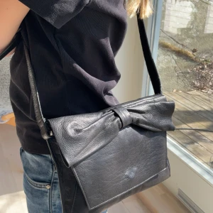 Väska - Säljer denna bedorande väska med en söt rosett på. Säljer då den inte kommer till användning❤️ Skriv för fler bilder eller frågor