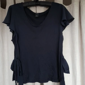 Luftig blå blus - Mainblå blus från lindex. Blusen väldigt lätt på, tunt material och lugtig. Den har funa detlaker på båda sidorna dör man kan knyta en rosett.