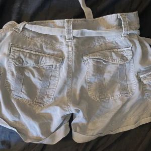 Lågmidjade shorts - Shorts i mörkgrå färg. Har ett bälte/snöre runt midjan. 