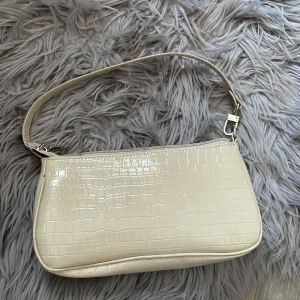 Handväska - En beige handväska som jag köpte här på plick, den är originellt från Shein. Säljer den för att jag inte tycker om den längre, inte min stil. Köpte den för 160kr 
