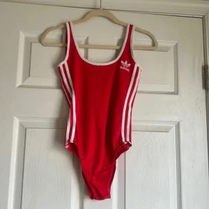 Röd Adidas Bodysuit - Röd Adidas Bodysuit, superfin men var för stor för mig så måste tyvärr sälja vidare. Passar en S-M eller en XS med större byst. 