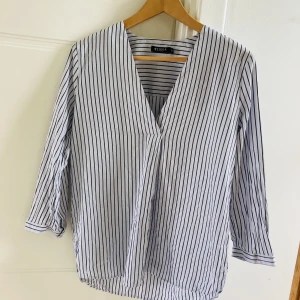 Skjorta Tiger of Sweden - Supersnygg blus/ skjorta från Tiger of Sweden i bomull/siden. Ljusgrå med svarta ränder, trekvarts ärm. Fint skick! 🌸