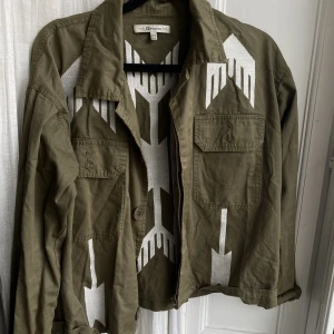 Militärgrön jacka  - Militärgrön jacka med detaljer, fint skick 