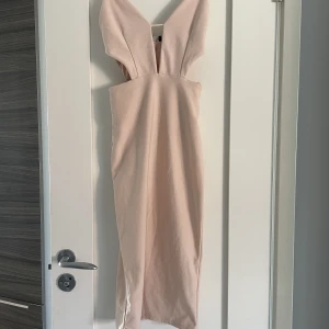 Ljusrosa klänning - Ljusrosa klänning med öppningar, använd fåtal gånger. Lappen är bortklippt men är en XS. Minns inte varifrån. 