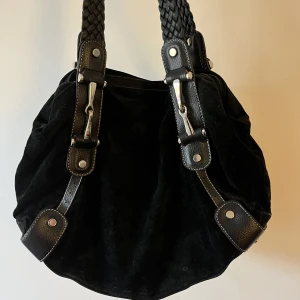 Svart medelstor väska  - En svart medelstor väska som rymmer dator! Har även praktiska fack, och själva väskutrymmet är delat i två. En detalj som är lite trasig men annars bra skick💕