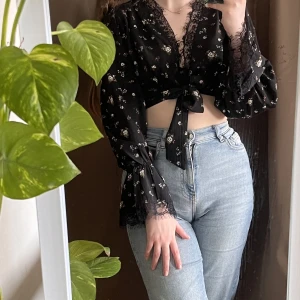 Blommig topp med spets 🌸 - Kort topp med spets som knytes vid bysten. Volangärmar med spets. Missguided petite. ➰