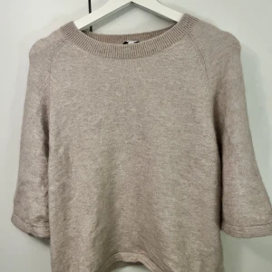 Stickad T-shirt - Jättefin beige/rosa stickad T-shirt i alpackaull ifrån & Other Stories. Använd 1 gång och passar perfekt till hösten. Sann i storlek.