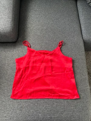 Röd silkes topp/linne - Röd silkes topp från Zalando (JJXX) i nyskick. I storlek XL men liten i storlek så hade även passat L