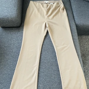 Utsvängda kostymbyxor i beige  - Utsvängda kostymbyxor i beige från H&M. I storlek EU46 men små i storleken och hade passat EU44. 
