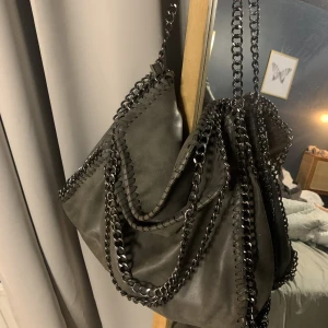 Grå kedje väska som liknar Stella McCartney  - Grå väska me kedjor som liknar Stella McCartney, skriv bara om du undrar nått💕