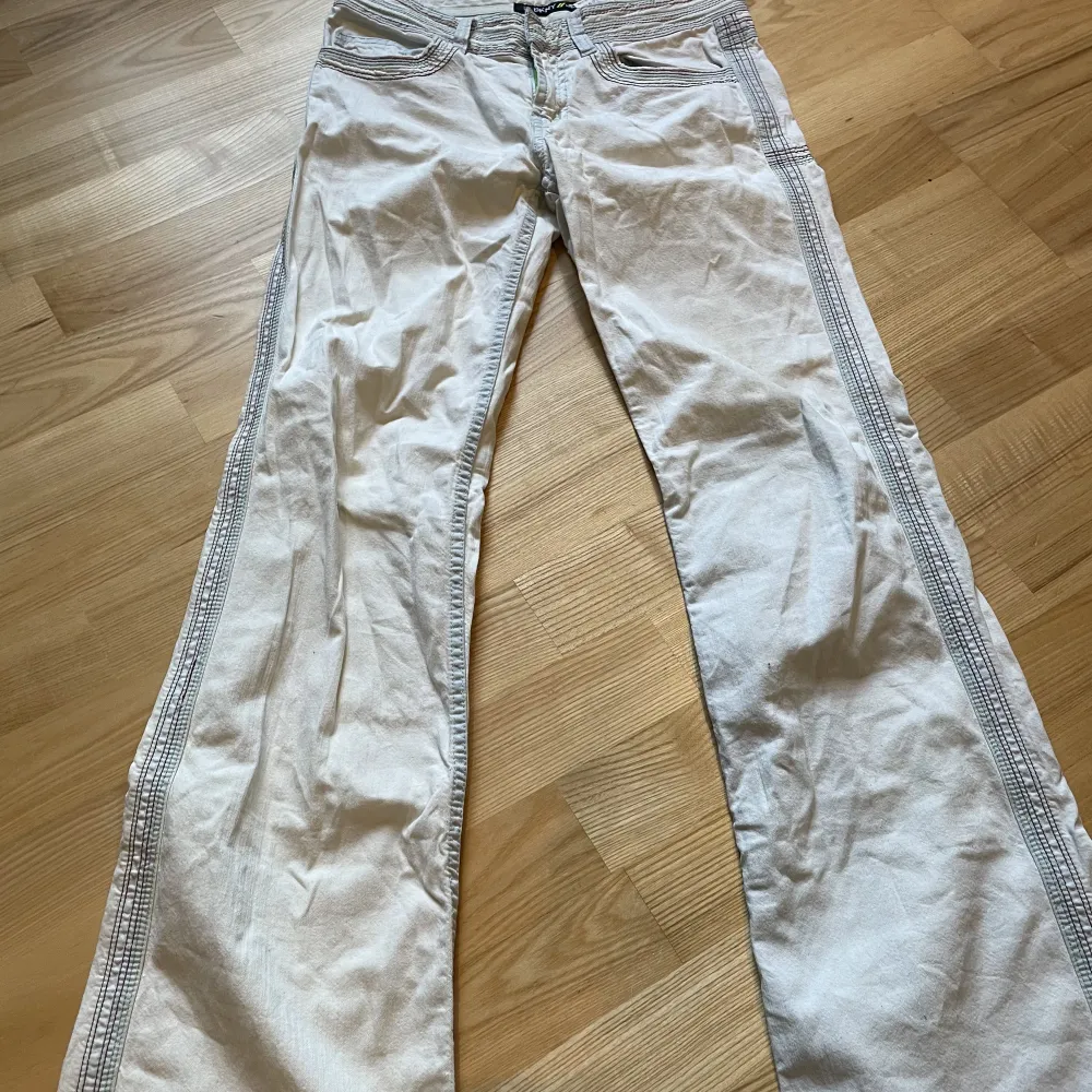 Vita utsvängda jeans med regnbågsfärgade stygn! Från DKNY-jeans!. Jeans & Byxor.