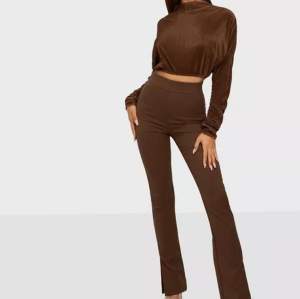 Bruna kostymbyxor med slits och brun plisserad topp! Från Biancas kollektion med Nelly. Aldrig använt så väldigt fint skick. Snyggt att bära ihop eller separat. 