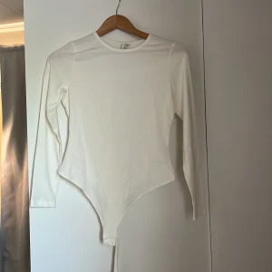 Långärmad body  - Köpt från nelly. Aldrig använd! Lite mer åt de benvita hållet. 