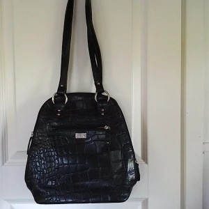 Skinnväska  - Välvårdad md flera innerfickor med dragkedjor. Ficka för mobil. 2 ytterfickor med dragkedja 