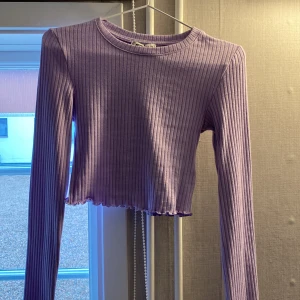 En lila tröja  - En långärmad tröja med ränder 