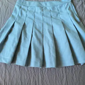 En blå kjol i storlek 38. Den här en liten fläck men den syns knappt då mönster eller vad man ska säga tänker den. Annars är den i fint sick och inte använda så mycket.