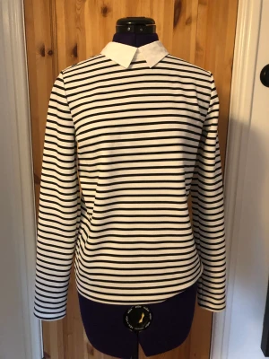 Randig topp med skjortkrage - Vit- och svartrandig långärmad topp från Only i storlek M. Mycket bra skick och normal i storleken.