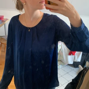 Mörkblå blus - En fin blå blus köpt på Åhléns för länge sedan, den är väldigt tunn men passar till alla årstider då den passar både med kjol och kostymbyxor🦋Tröjan har även en öppning i ryggen som gör den mer exklusiv. Tyget är lite som mesh blandat med siden🎀