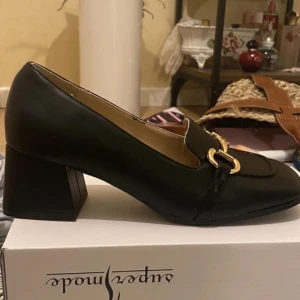 Läder Pumps med guld detaljer 💋 - Säljer HELT NYA- OANVÄNDA svarta pumps. Skornas klack är block heel som är cirka 5cm.  Eftersom de är helt nya följer deras helt oskadade, original skolåda med, tillsammans med fint skyddspapper som kom tillsammans med skorna. Mycket lätta och bekväma 😊