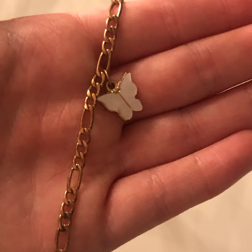 Guld armband med fjärils berlock från shein. Använt fåtal gånger . Accessoarer.