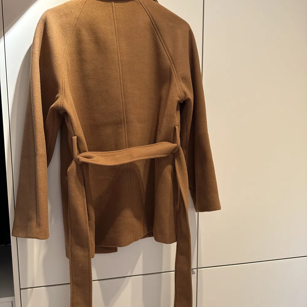 Kort ljusbrun kappa från Gina tricot, använd ett  fåtal gånger, nypris 599 kr. Jackor.