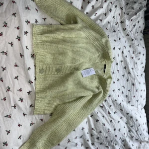 Stickad kofta  - Stickad kofta från GinaTricot i en gulgrön färg. Aldrig använd. Nypris 399kr. 