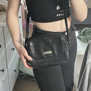 Svart axelremsväska i läder  - En svart läderväska med jättemånga fack! Den är även i väldigt bra skick. 