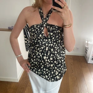 Topp - Assnygg svart topp med vita blommor på, knytning i ryggen. ❤️