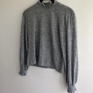 Grå tröja med volanger  - Säljer en jättefin grå tröja med volangdetaljer vid kragen och ärmarna💕 Jättefint skick och skönt, mjukt material! Säljs på grund av brist på användning. Rensar bland kläderna så kolla gärna mina andra annonser 🤗