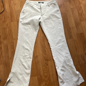 Vita lågmidjade kostymbyxor vit - Vita lågmidjade kostymbyxor från bikbok! Använda men bra skick inga skador eller märken. Storlek 38🩷