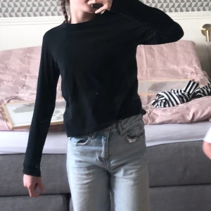 Svart långärmad tröja  - En svart långärmad tröja. Tröjan är i fint skick men har tyvärr börjat bli lite kort i armarna. Tröjan är i storlek 134/140