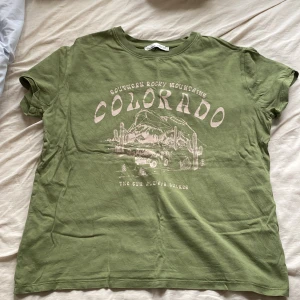 Grön T-shirt - En grön T-shirt köpt från PULL&BEAR för 200kr säljer för 100kr. Storlek Xs. Säljer för att den inte kommer till användning.