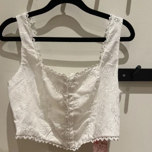 Vit topp - Supersöt vit topp. Helt ny och aldrig använd, pga för liten för mig. I storlek M/L är dock lite liten i storlek enligt mig. Ordinarie pris 120kr och prislapp kvar.