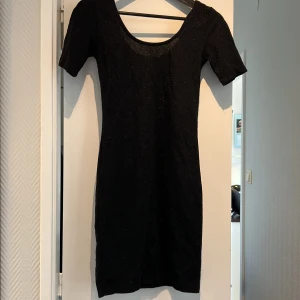 Glittrig fodralklänning  - Glittrig svart klänning, kort och tight. Passar till nyår! Sitter fint på. Aldrig använd då jag är för lång 