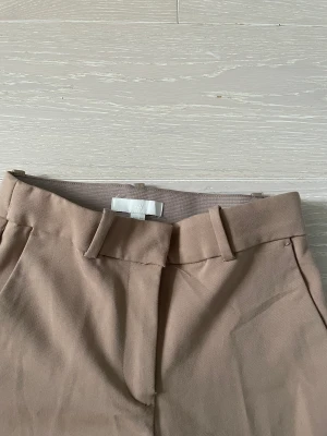 Kostymbyxor - Högmidjade kostymbyxor från hm. Använda ungefär 5 gånger. Säljer pågrund av att den inte är min stil💕