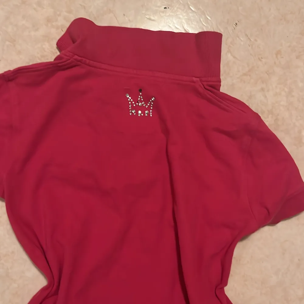 Rosa skjorta i liten storlek ( två paljetter har åkt av från kronan på baksidan av skjortan ). Skjortor.