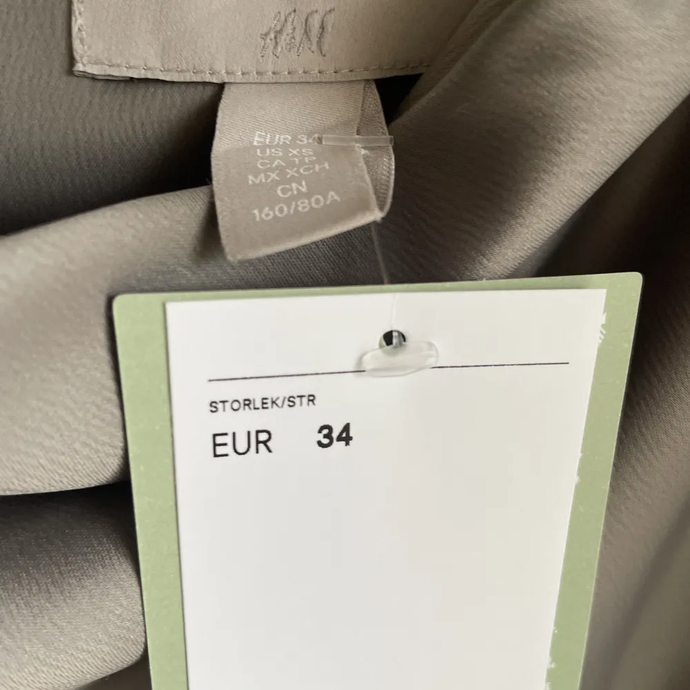 Jumpsuit från H&M.  Storlek: 34 Material: Polyester Nypris: 300 SEK Helt ny, med prislapp kvar.  Kommentar från säljaren: Snygg grå festlig jumpsuit som tyvärr är för lång. Vida fina byxor och fin urringning. Klänningar.