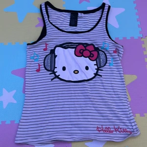 Randigt hello kitty linne - Säljer för att jag har tappat intresse i den och den knappt använts, super söt och har inga  hål! har en liten fläck på ryggen (bild 3) men den går säkert att tvätta bort! Klicka på köp om du vill köpa, kontakta om du har frågor!