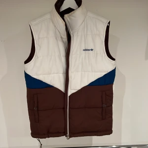 Adidas täckväst - Husses brunvita täckväst har han använt väldigt lite. Dock finns det ett par fläckar på den som jag absolut INTE är skyldig till 🙀(ska testa lite fläck-väck på dem). 😻Vändbar, helbrun på insidan. Tror det är storlek L. 👍🏻🐈