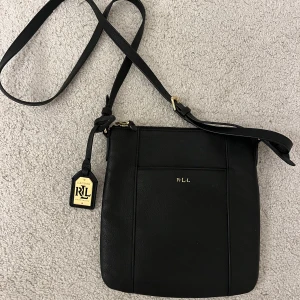 Ralph Lauren väska - Ralph Lauren - RLL i mycket bra skick. Mått höjd: 23cm Bredd: 22cm Djup : 2cm  Svart läder 