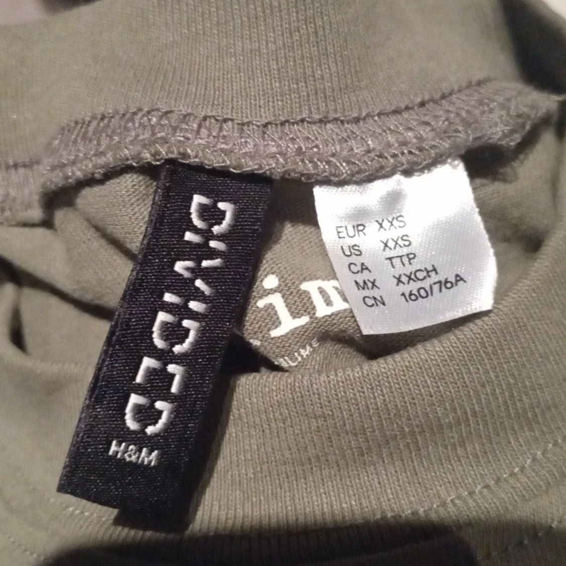 En militär grön tröja med en sol - 90