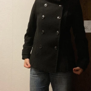 Svart kort kappa - Kort kappa i strl 38 (går att ha som 40 också). Köpt på HM för länge sen men säljs då den tyvärr inte blivit till användning på senaste. Den har inget direkt slitage utan är fortfarande i superskick🙌 Pris kan diskuteras vid snabb affär<3