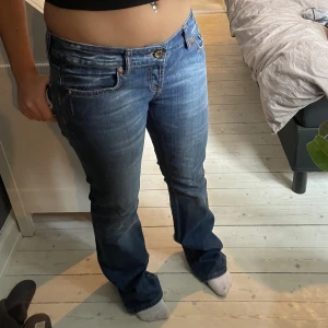 Lågmidjade jeans - Ett par snygga Lågmidjade jeans med detaljer på baksidan, köpta secondhand. Det står ingen storlek i byxorna men jag har W30. De är väldigt långa i benen och jag är 1,66💓