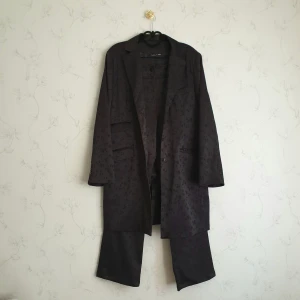 Svart kavaj set - ☀️FÖRST TILL KAVRN☀️ Superfin svart kavaj set med lyxig blommig jaquard vävd tyg. Perfekt till att se professionell ut. Strl 44, som S/M användes endast kavajen med en guldig kedjebälte för en oversized look✨️ nyskick. Kavaj använd 2 ggr, byxor oanvända.