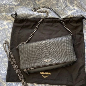Zadig väska - Rock savage clutch väska från Zadig&Voltaire. Köpt för 3900kr i slutet av juni 2022. Har inte använt den så mycket. Därav inga defekter. En lång kedja och dustbag medföljer. Fler frågor? Bara fråga på!❤️