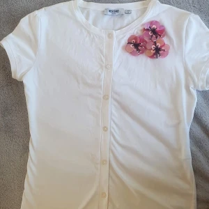 Moschino y2k T-shirt  - Super snygg vintage y2k T-shirt från Moschino. Super fin med rosa blomm detalj i paljett. Knappar. Italiensk 44, passar mig som har xs-s💗