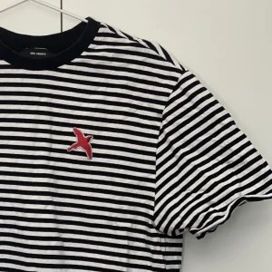 Axel Arigato t-shirt  - Knappt använd t-shirt från Axel Arigato. Storlek Herr L men väldigt liten i storleken, snarare M Dam.  Säljs inte längre.