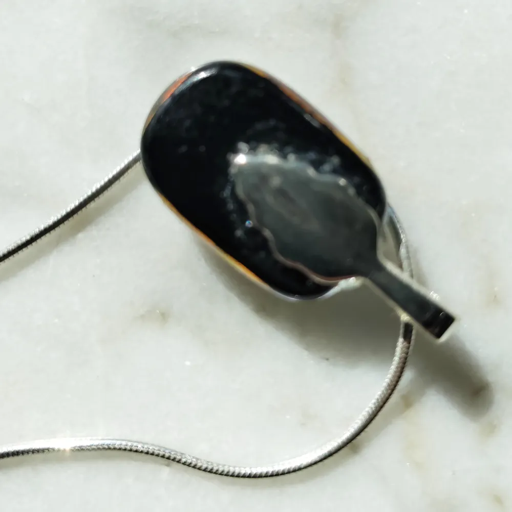 Hängsmycke i rödskimrande glas med silverpläterad hänge. Kedjan (925 Sterlingsilver) kan köpas separat. Glaset mäter ca 2 cm.. Accessoarer.